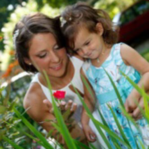 Bride and Flower Girl Looking at a Red Flower Bride and Flower Girl Smiling while admiring a Red Flower